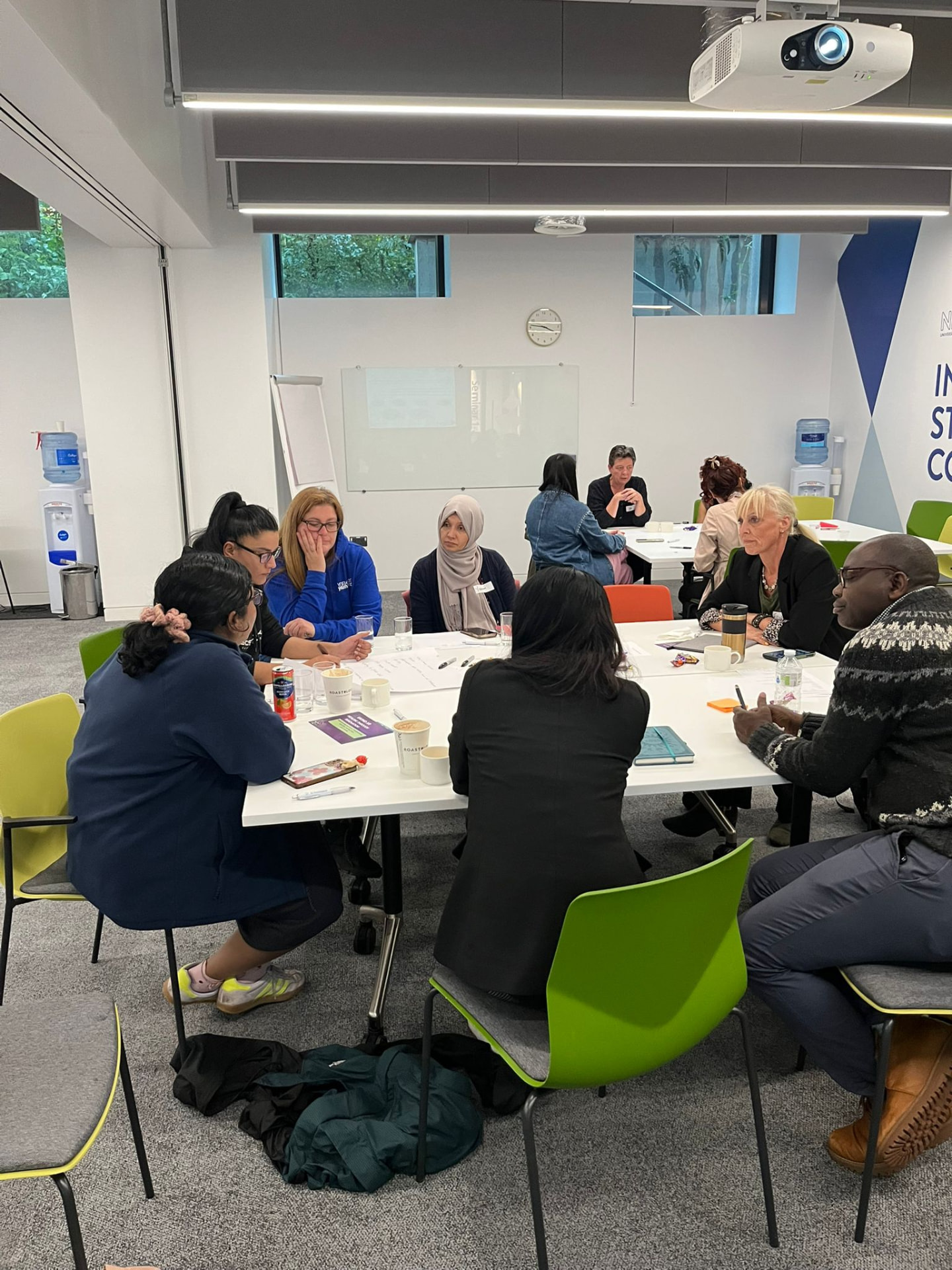 A co-design session in progress with practitioners and survivors around a table