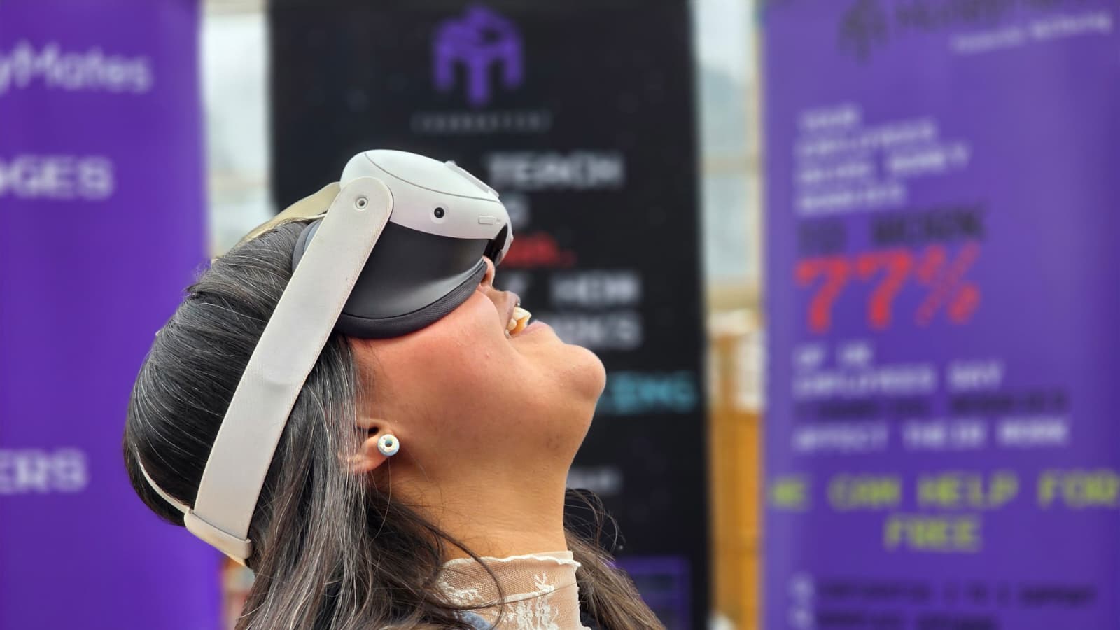 A participant smiling while looking up through a UKind XR headset at a demonstration event